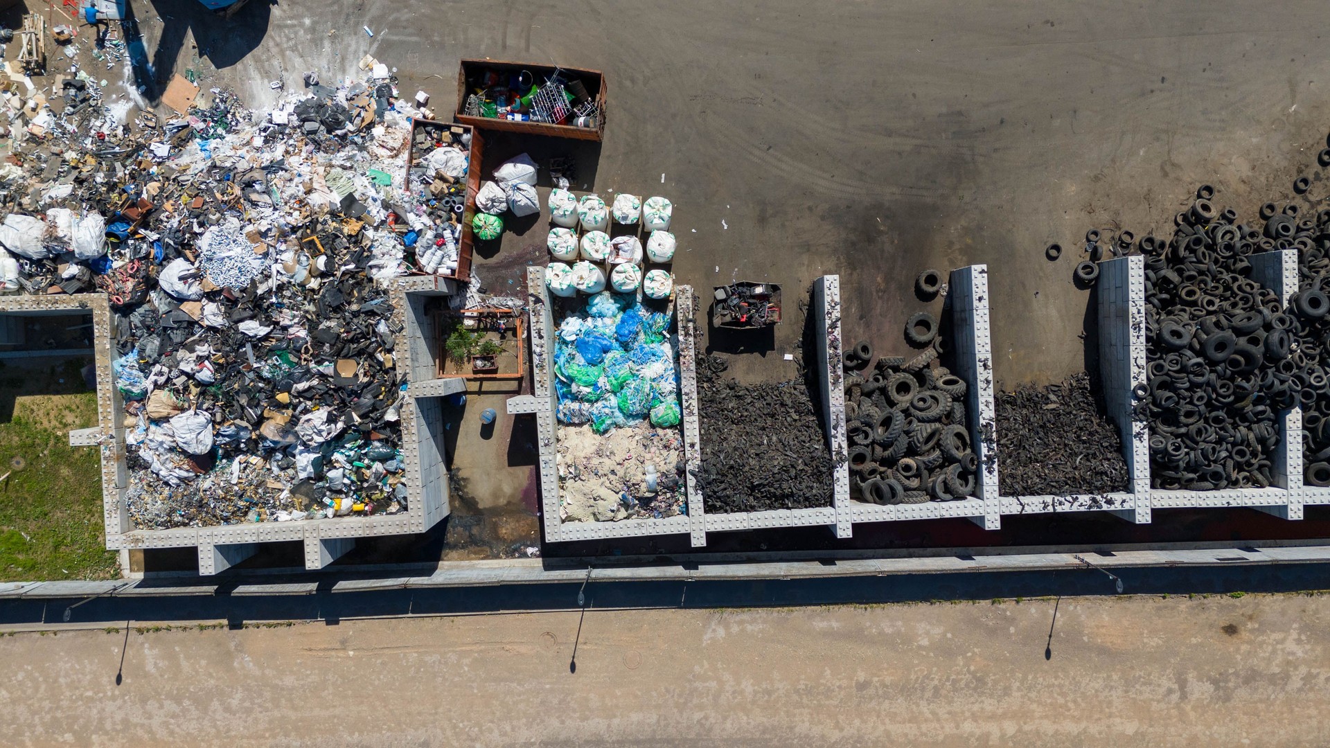 Drone photography of recycling center and machinery sorting material during summer day